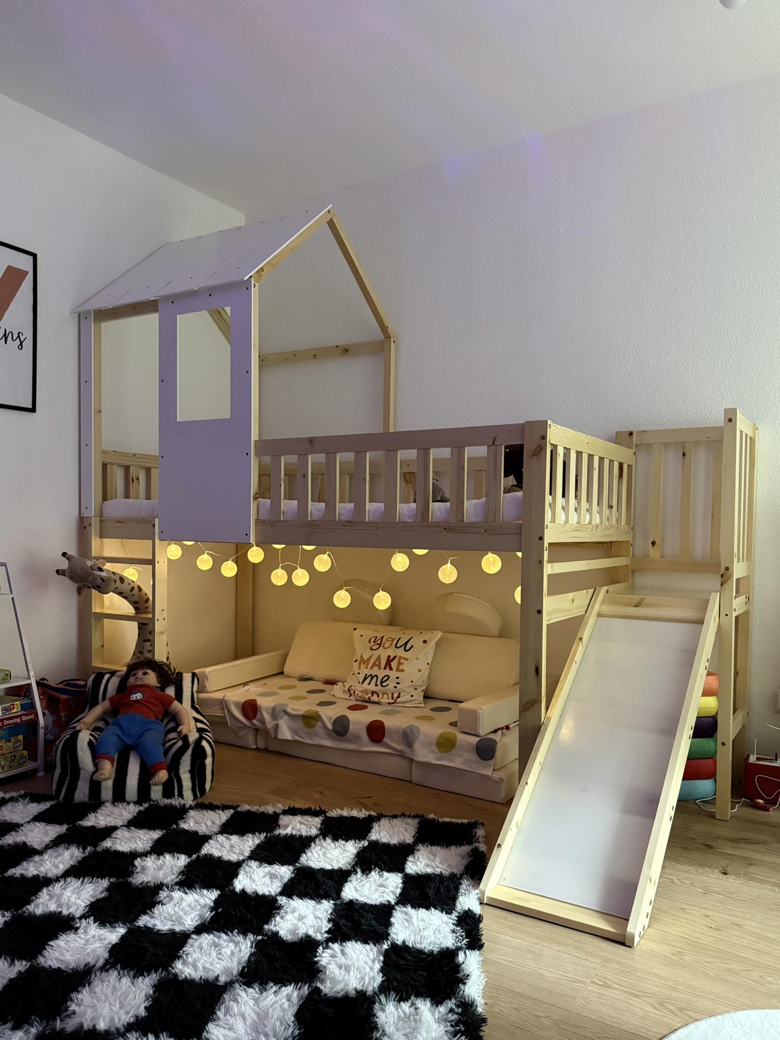 Hausbett mit Rutsche und warmer Lichterkette – gemütlicher Schlaf- und Ruhebereich