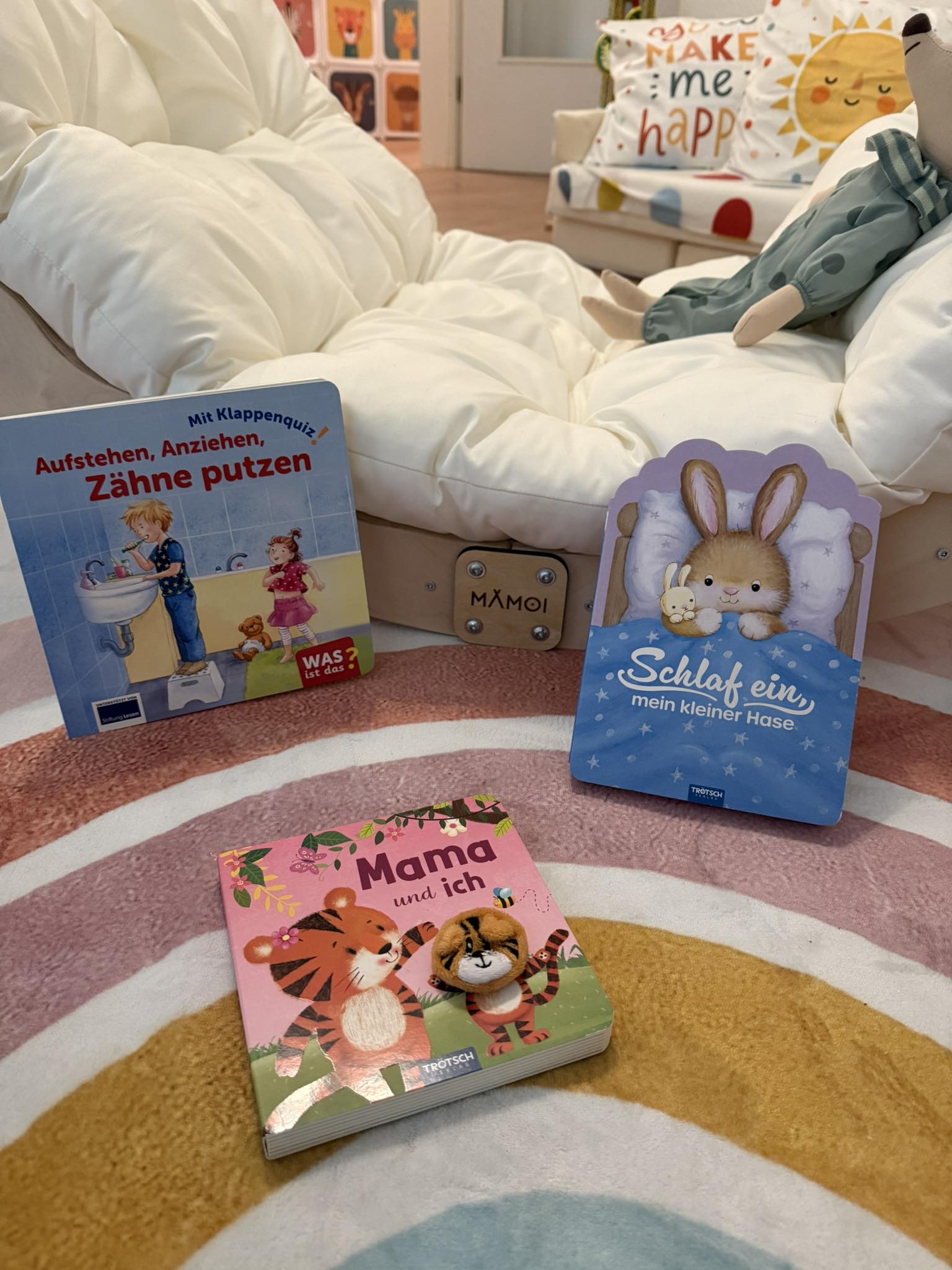 Leseecke mit Bilderbüchern auf einem Regenbogen-Teppich